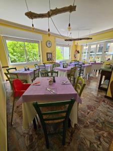 Villa Pina في لايقويليا: مطعم بطاولات وكراسي وساعة على الحائط