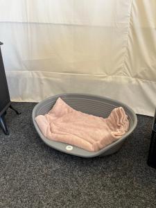 a blanket is sitting in a pan on the floor at Dukeries Retreat in Retford