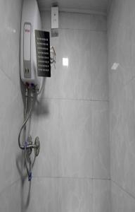 a shower in a bathroom with a phone on the wall at Ared Space-Near Vile Parle Railway Station in Mumbai