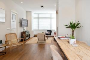 een woonkamer met een houten tafel en stoelen bij The White House in Zandvoort