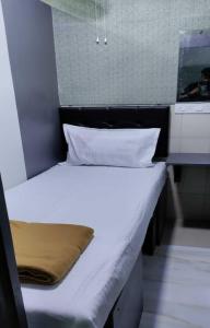 a bed with white sheets and pillows in a room at Ared Space-Near Vile Parle Railway Station in Mumbai