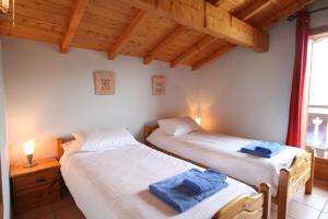 2 Einzelbetten in einem Zimmer mit Holzdecken in der Unterkunft Chalet The Loft in Les Gets