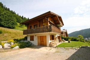 ein Haus mit Balkon auf einem Hügel in der Unterkunft Chalet The Loft in Les Gets