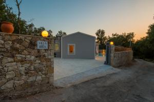 a small house with a stone wall and a stone fence at Villa Irida in Plátanos