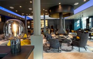 um átrio com cadeiras e uma grande iluminação em Best Western Premier Le Chapitre Hotel and Spa em Remiremont