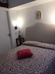 Un dormitorio con una cama con una almohada roja. en Casa vacanza, en Capri