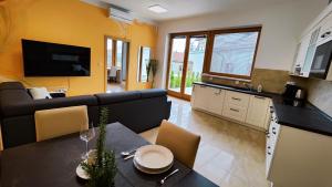 a kitchen and a living room with a table and a couch at Apartmány Dačice in Dačice