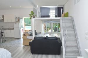 ein Wohnzimmer mit einem Sofa und einer Treppe in der Unterkunft Casa Nodica in Tacoronte
