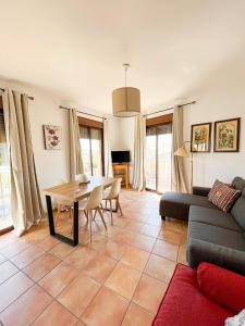 sala de estar con mesa y sofá en Apartamentos Villa Torcal, en Villanueva de la Concepción