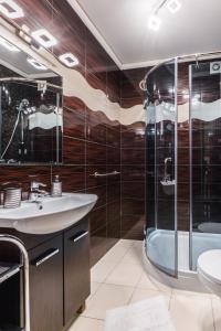 a bathroom with a shower and a sink and a tub at Czerwone Wierchy & Spa in Zakopane