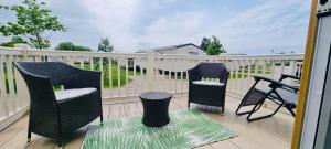 2 Stühle und ein Tisch auf einer Terrasse in der Unterkunft RJ Luxury caravan hire 2 with Hot Tub in Tattershall