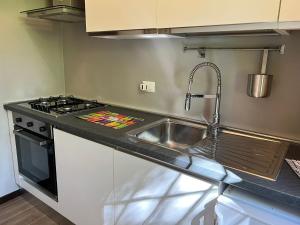 a kitchen with a sink and a stove at Bnbook Casa Luccio VistaLago Ispra in Ispra