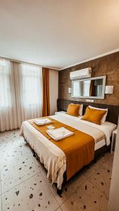 Habitación de hotel con 2 camas con sábanas de color naranja en Tonoz Beach Hotel, en Ölüdeniz