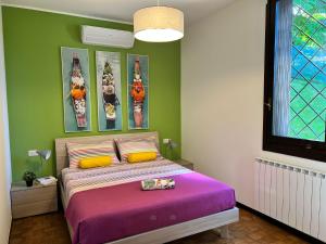 una camera con un letto e una coperta viola di Bnbook Casa Luccio VistaLago Ispra a Ispra