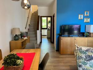 a living room with a table and a tv at Bnbook Casa Luccio VistaLago Ispra in Ispra