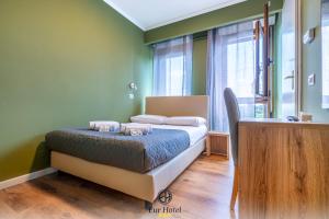 um quarto com uma cama num quarto com paredes verdes em EURHOTEL em Florença
