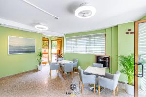 uma sala de espera com paredes verdes e mesas e cadeiras em EURHOTEL em Florença