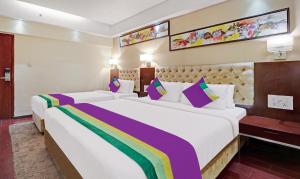 una camera d'albergo con due letti con cuscini colorati di Hotel Park N a Vijayawāda Altre 71 foto