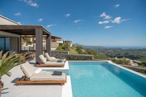 a villa with a swimming pool with lounge chairs at Villa Amavi - Private heated pool in Kato Asites