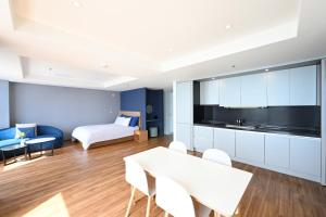 a living room with a couch and a table and chairs at Kolon Seacloud Hotel in Busan