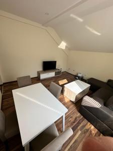 uma sala de estar com uma mesa branca e um sofá em Five Apartments Boska Buhe em Inđija