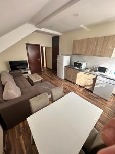 uma sala de estar com um sofá e uma mesa em Five Apartments Boska Buhe em Inđija