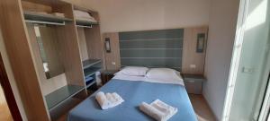 a small bedroom with a blue bed with two towels at Hotel Villa Argentina in Riomaggiore