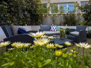 eine Terrasse mit einem Tisch, Stühlen und Blumen in der Unterkunft Ambiorix Residence in Brüssel