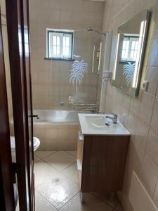 un bagno con un lavandino, una vasca e uno specchio di Monte Gordo T1 - Estrela do Mar a Monte Gordo