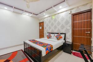 a bedroom with a bed and a wooden door at FabExpress Amazing Inn in Bangalore