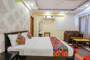 a bedroom with a bed and a couch and a chair at FabExpress Amazing Inn in Bangalore