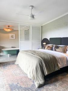 a bedroom with a large bed and a bath tub at Rockwood Karkloof Farm House and Farm Cottage in Howick