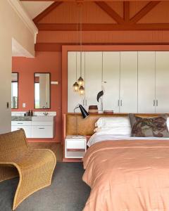 ein Schlafzimmer mit einem großen Bett und einem Waschbecken in der Unterkunft Rockwood Karkloof Farm House and Farm Cottage in Howick