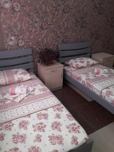 two twin beds in a room with a wall at ERA Hotel in Gyumri