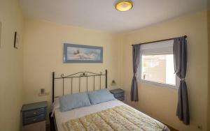 a bedroom with a bed and a window at ATICO CON TERRAZA EN EL CENTRO Albert Villas in Alcossebre