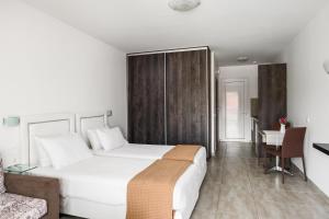 a bedroom with a large white bed and a couch at Delight Corfu Apart Hotel, Sidari in Sidari