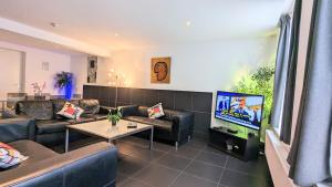 a living room with couches and a flat screen tv at The Hotel Apartments in the Center of Amsterdam in Amsterdam