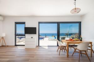 a dining room with a table and a view of the ocean at Sun Resort Apartments in Zečevo Rogozničko