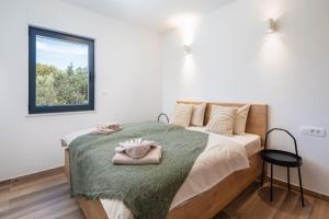 1 dormitorio con 1 cama con manta verde y ventana en Sun Resort Apartments, en Zečevo