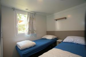 a room with two beds and a window at Camping Adria Mobile Home Park Umag in Umag