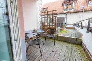 einen Balkon mit einem Tisch und Stühlen auf einem Gebäude in der Unterkunft Hotel Freischütz in Landshut