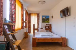 ein Schlafzimmer mit einem Bett und einem TV in einem Zimmer in der Unterkunft Hotel Freischütz in Landshut