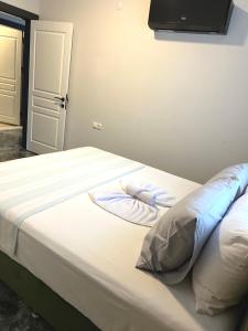 Schlafzimmer mit einem Bett mit weißer Bettwäsche in der Unterkunft Vega Villalari in Fethiye