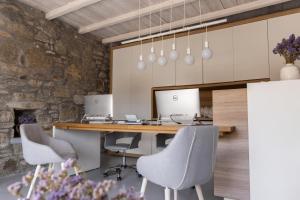 a kitchen with a table with chairs and two computers at Senses Luxury Suites & Villas in Elia Beach