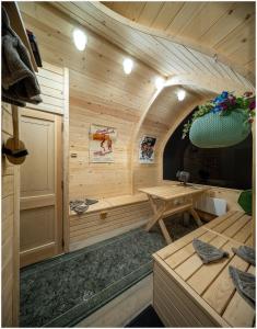 eine Holzsauna mit einem Holztisch in einem Zimmer in der Unterkunft Guest house Lilac in apple tree park in Nākotne