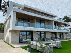 a building with chairs and tables in front of it at Gold Wave Apartments in Siófok