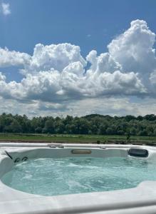 une piscine avec un ciel nuageux en arrière-plan dans l'établissement ВАЛ Къща за Гости - яз Жребчево, à Tvŭrditsa