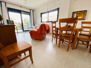 uma sala de estar com um sofá, uma mesa e cadeiras em Apartamentos Porta Mediterranea Altamar em Alcossebre