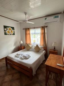Un dormitorio con una cama grande y una mesa. en Happy stay villa, en Grand'Anse Praslin 37 fotos más