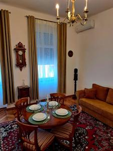 a living room with a table and chairs and a couch at Weisz Castle style Apartment-City Center-Free Private Parking,Wifi,Air conditioner in Carei